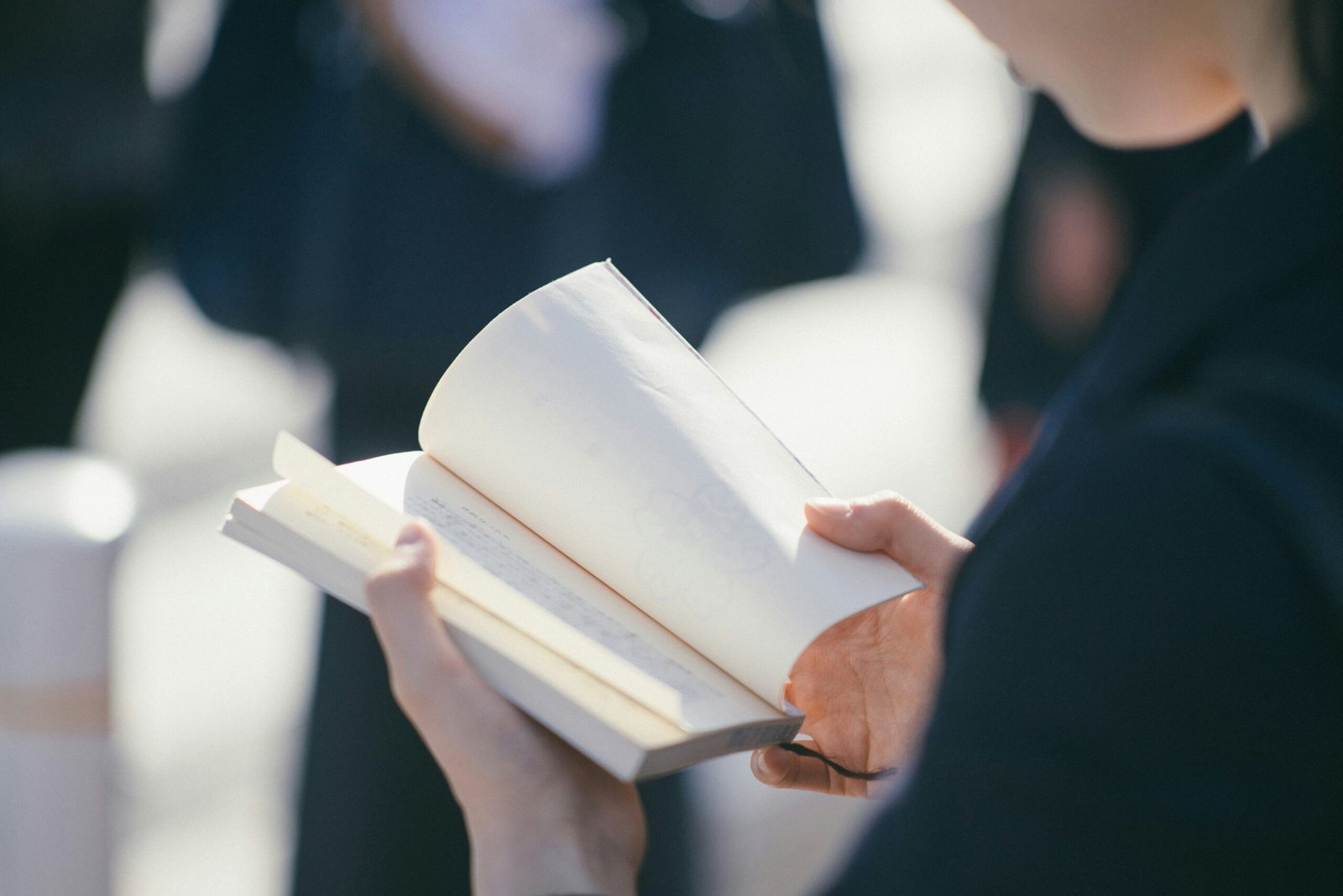 standing woman reading book at daytime